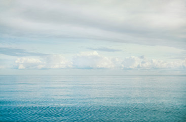 Landscape with cumulus and continuous clouds over the turquoise sea.