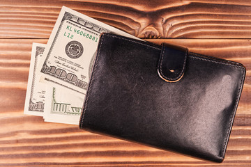 Wallet with american dollars on wooden table