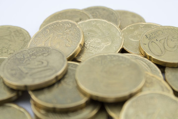 Several twenty euro cent coins on white background. Coins with little value.