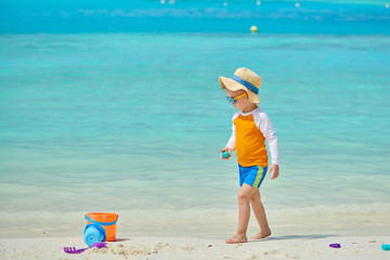 Three year old toddler playing on beach