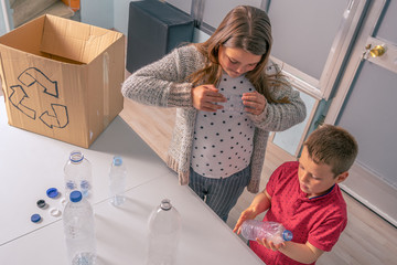 children recycling bottles and plastic caps, funny attitude