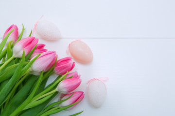 Pink Tulips and Easter Eggs isolated on white wood Background.