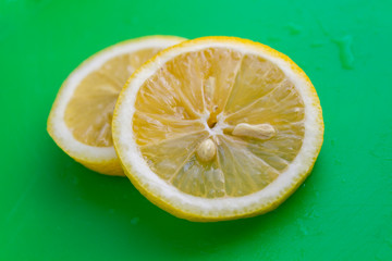 sliced lemon on green background 