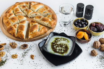 Iftar meal (time to break the fast) with Traditional Turkish Soup,sweet dry dates,apricot,black olives,water and Ramadan bread on the round wooden board.Beginning meal before main menu.