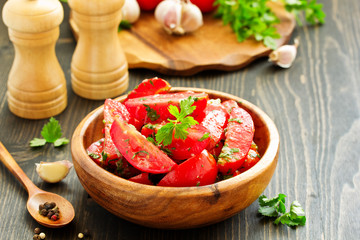 Appetizer of salted tomato with garlic and herbs.