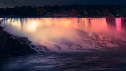 Niagara Falls at night seen from Canadian side, illuminated by colorful lights