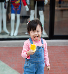 Pretty little girl eating  ice cream outside