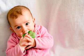 Adorable funny baby girl smiling with pink pajamas.