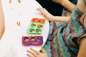 hands of a child, a master class in cooking chocolate, folding fruit and chocolate into molds