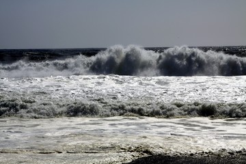 White breakwater foam hit on lonely black lava sand beach at Pacific coastline - Cobquecura Piedra De La Loberia, Chile