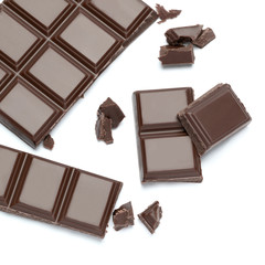 Dark organic chocolate pieces isolated on white background