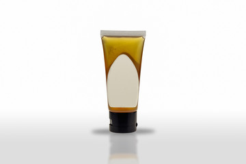 The plastic tube package containing the product has a white label isolated on white background.
