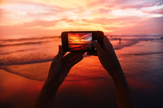 Girl takes a sunset photo on the phone