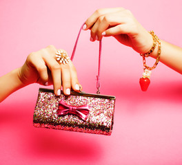 little girl stuff for princess, woman hands holding small cute purse on pink background
