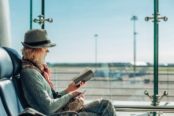 Young woman reading a book at the airport