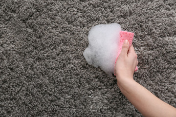 Woman cleaning carpet at home
