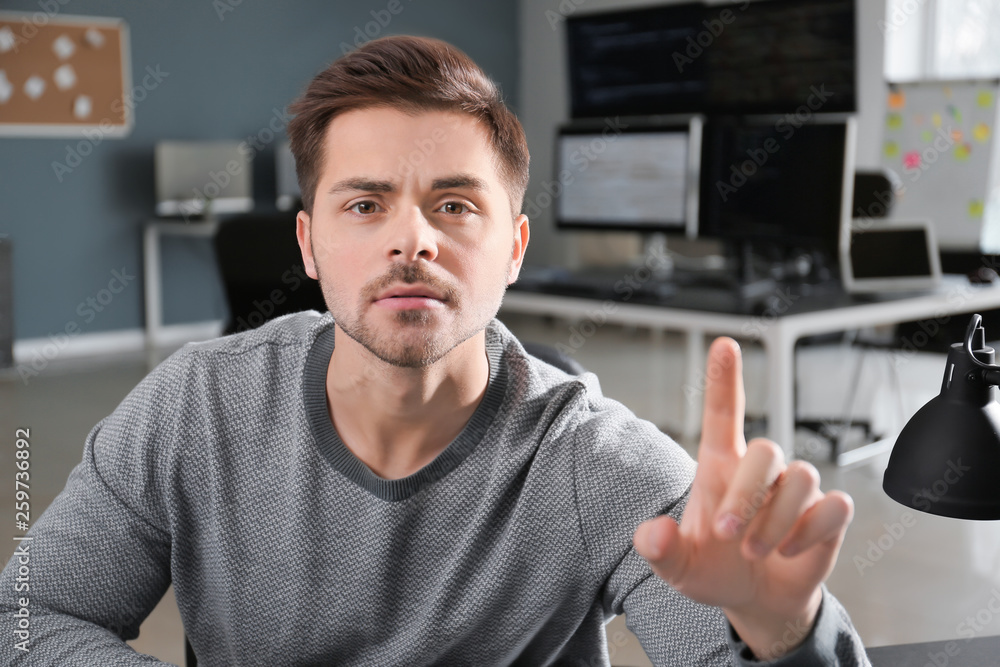 Poster male programmer using virtual screen in office