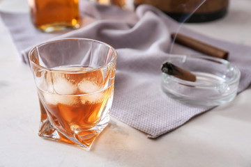 Glass of cold whiskey on light table