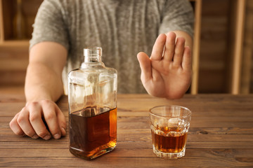 Man refusing to drink whisky in bar