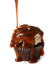 Pouring of liquid caramel onto cupcake on white background