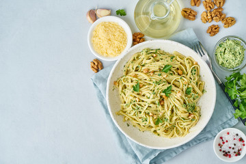 Pesto pasta, bavette with walnuts, parsley, garlic, nuts, olive oil. Top view, copy space, blue...
