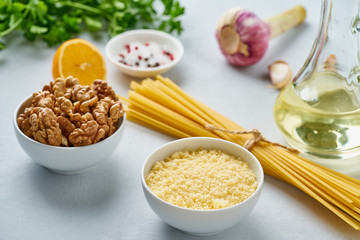 Step by step recipe. Pesto pasta, bavette with walnuts, parsley, garlic, nuts, olive oil. Side view, blue background.