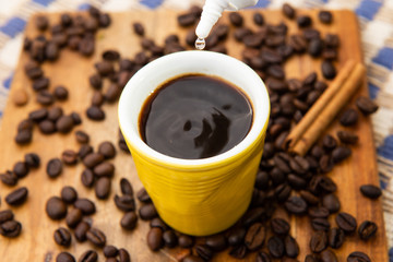 small cup of coffee being sweetened.