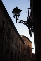 Fototapeta na wymiar piccola strada buia in un vecchio borgo al tramonto