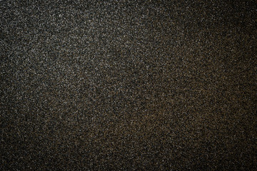Metallic glitter black background, close up. Dark gray paper backround. Black glitter background from wrapping paper.