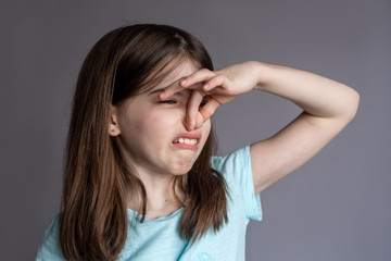 Young girl covering her nose with a bad smell