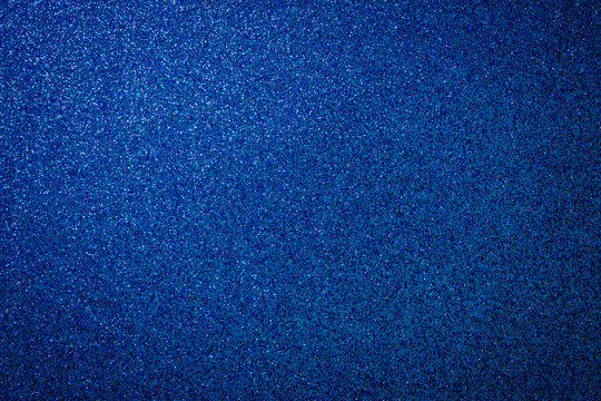 Metallic glitter blue background, close up. Dark gray paper backround. Blue glitter background from wrapping paper.