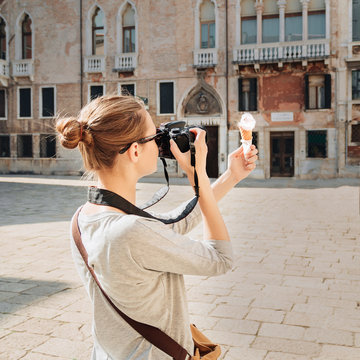 Girl takes pictures of ice cream on square in Venice