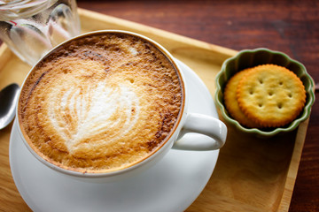 Cup of cappuccino coffee with heart shape latte art on old wood table Background, Latte coffee on old wooden Background table