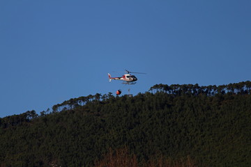 Firefighting helicopter flies over the mountain