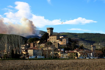 Fototapeta na wymiar the medieval village of Vicopisano with the Pisan mountains on fire 