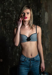Fototapeta premium Beautiful young girl in bodice and jeans in the old studio
