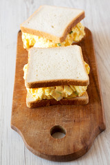 Homemade egg sandwich for breakfast over white wooden surface, low angle view. Close-up.