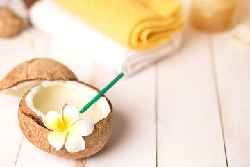 Coconut, spa products and towels on white background