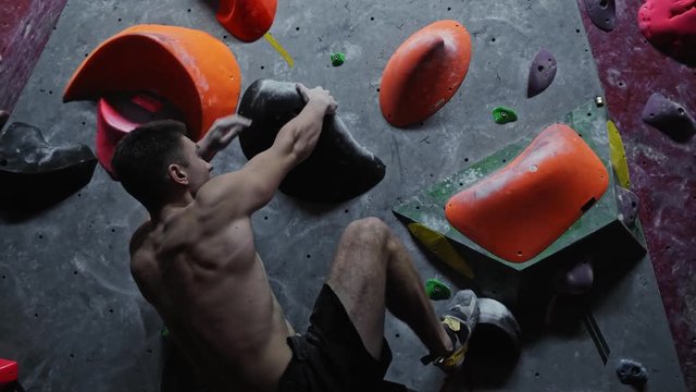 Athletic man practicing in a bouldering gym
