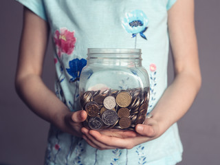 child holds in hand a box with money, pocket money of a child, concept