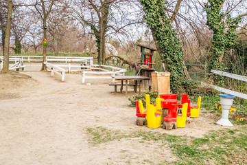 Wooden red and yellow benches and table under a tree