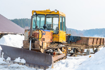 old yellow tractor in winter