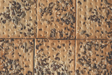 Crisp bread with seeds, top view, background.