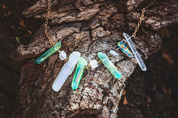 Natural crystal quartz stone necklace on natural wooden background