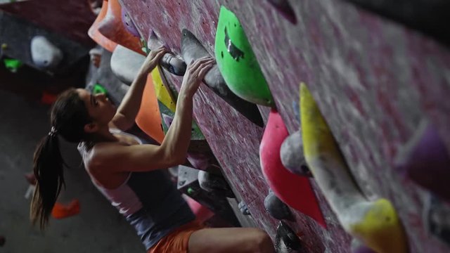 Athletic woman practicing in a bouldering gym