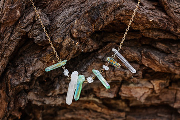 Natural crystal quartz stone necklace on natural wooden background