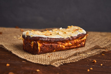 fresh classic vanilla cheesecake decorated by almond flake on wooden background