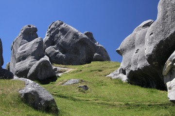 Castle Hill, New Zealand, South Island: Scattered Limestone boulders on a meadow contrasting with...