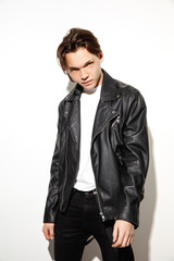 Fashion portrait of young cool hipster boy. Studio shot of model having serious face.