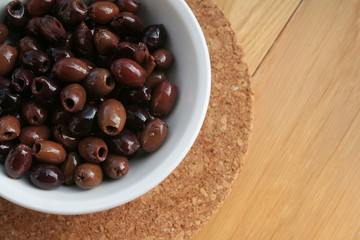 Italian Taggiasche olives in a bowl on wooden table